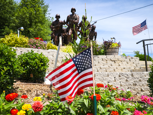 Flag and statue of soldiers in the Veterans Memorial Garden